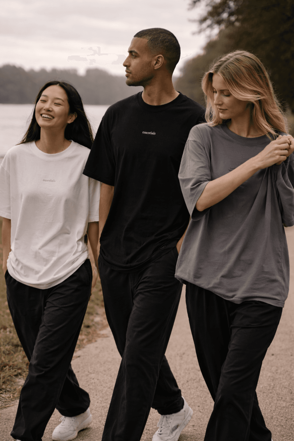 Friends walking beside a lake in oversized t-shirts